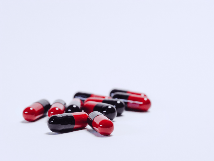 Red and black Ampicillin pills for dogs and cats.
