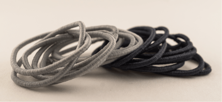 A pile of black and grey hair ties.