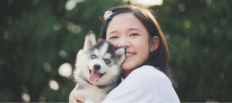 A child holds her beloved dog.
