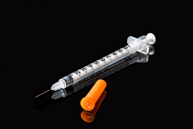 An Insulin Syringe on a Black Table