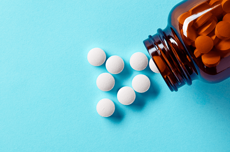 Diphenoxylate pills on a blue table