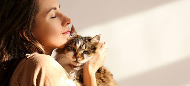 A woman thinks her cat is so cute that she wants to bite it.