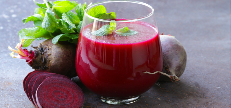 Sliced beets and beet juice in a glass.